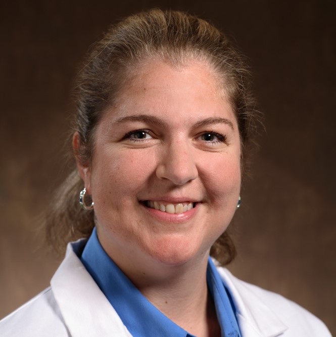 a smiling woman wearing a lab coat against a brown background 