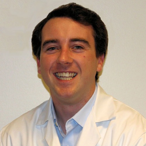 man smiling wearing a lab coat