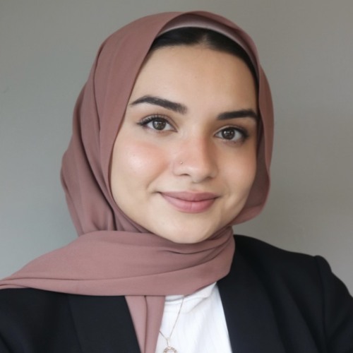 Woman smiling wearing a pink hijab, white blouse and black blazer