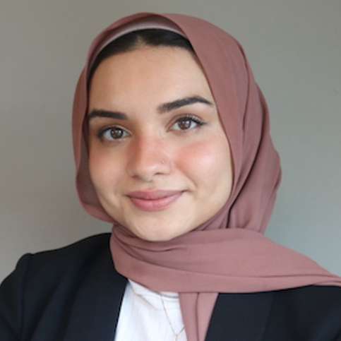 physician smiling wearing a black blazer and white button up shirt
