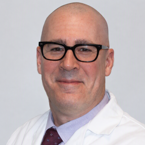 man smiling wearing glasses and a white lab coat