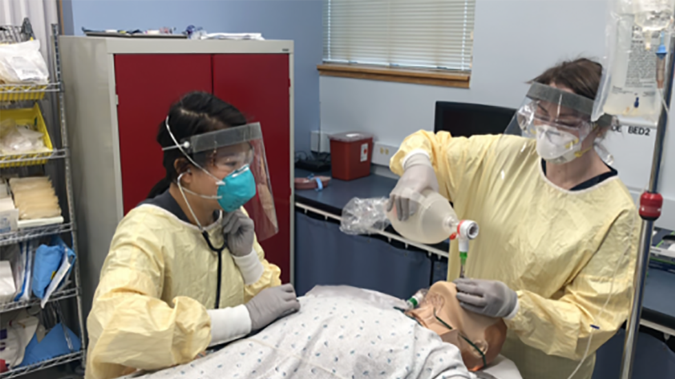 people in PPE working on a dummy