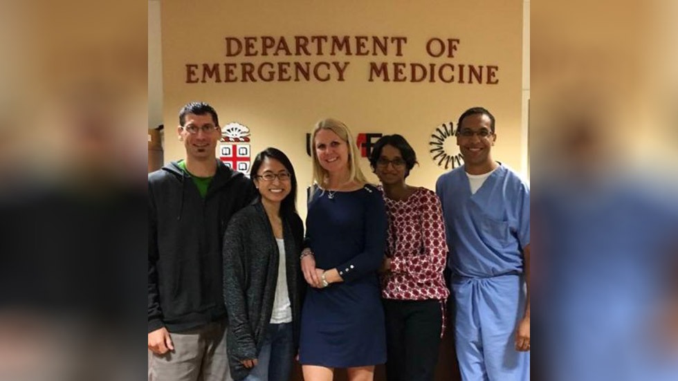 people posing in front of a sign that says Department of Emergency Medicine